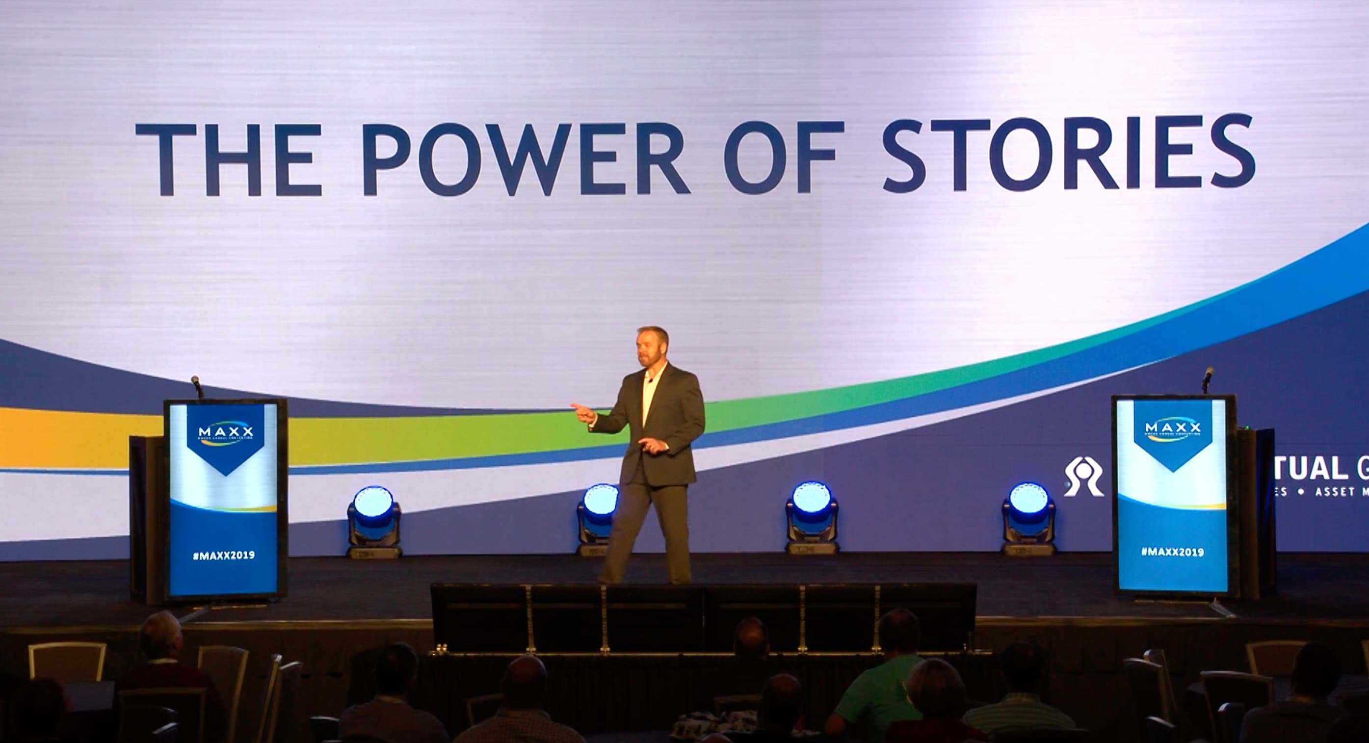 Dale Dixon presenting on a conference stage beneath The Power of Stories